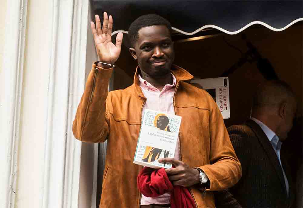 Mbougar Sarr posa com seu livro premiado, "La plus secrète mémoire des hommes" (Imagem: Divulgação)