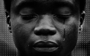 Jovem negro com lágrima escorrendo de seu olho.(Imagem: Rep/Revista Raça)