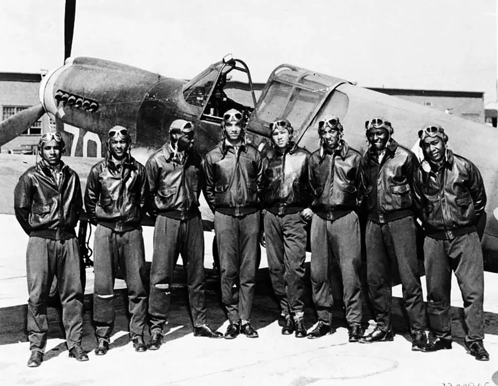 Oito Tuskegee Airmen em frente a um avião P-40