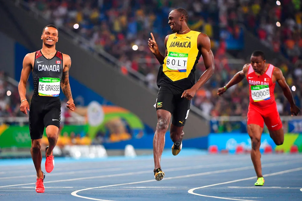 Usain Bolt rindo com adversário durante prova (Imagem: divulgação)