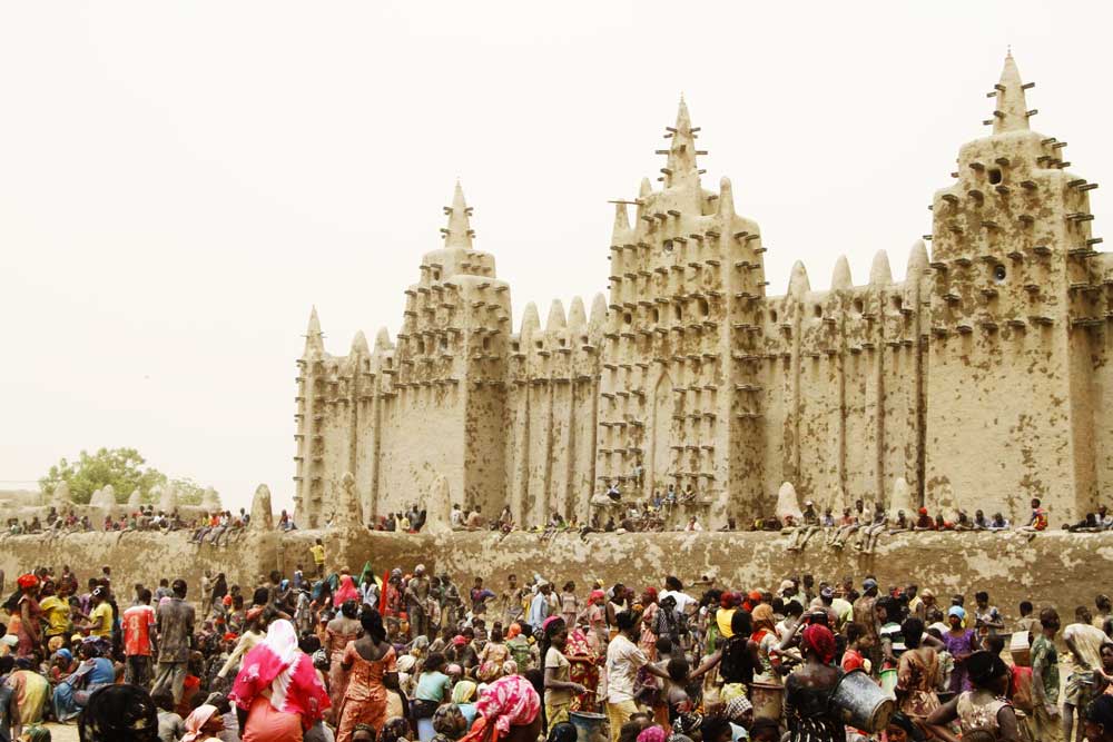 Pessoas em frente à Grande Mesquita de Djenné, localizada em Timbuktu (Imagem: Google Arts & Culture)