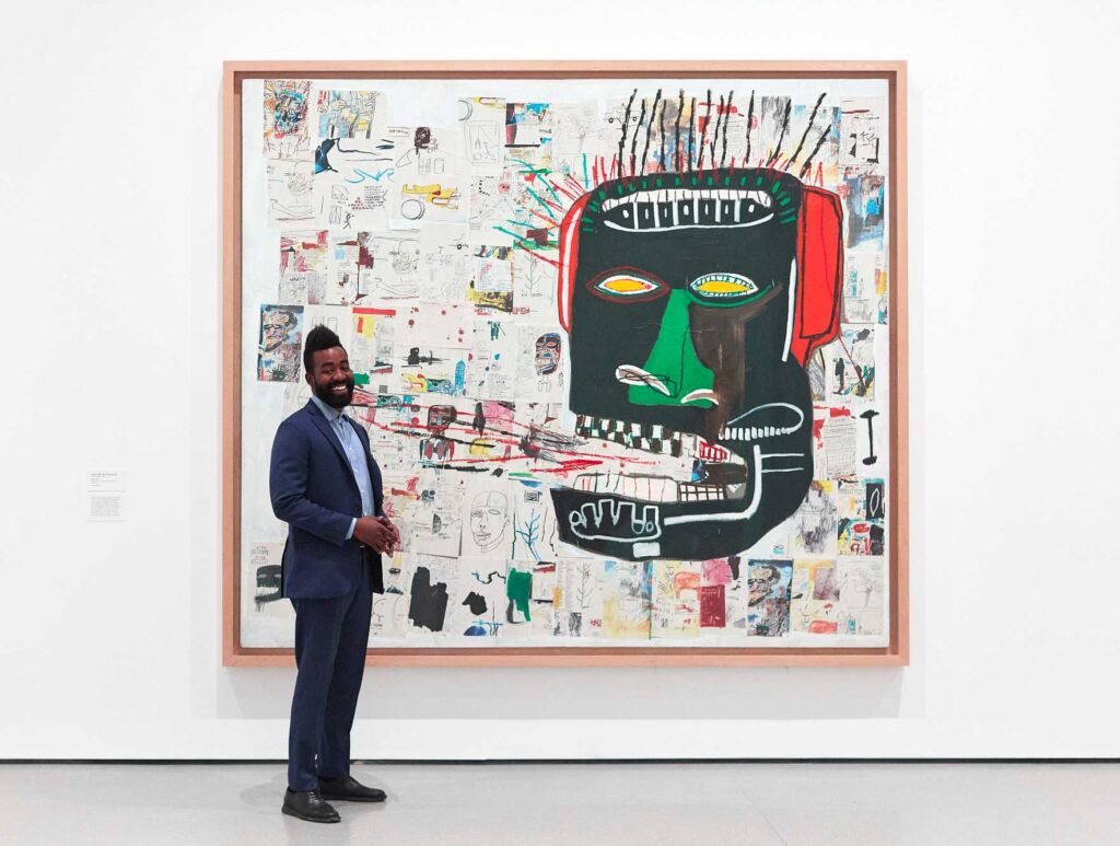 Glenn,1985 – Jean-Michel Basquiat (Imagem: Divulgação | Chet Gold, funcionário do museu e artista, posa em frente a obra exposta no Moma)