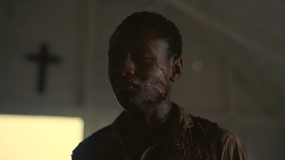 Cena do filme Pecadores dentro da igreja, mostrando cicatrizes no rosto de um dos personagens